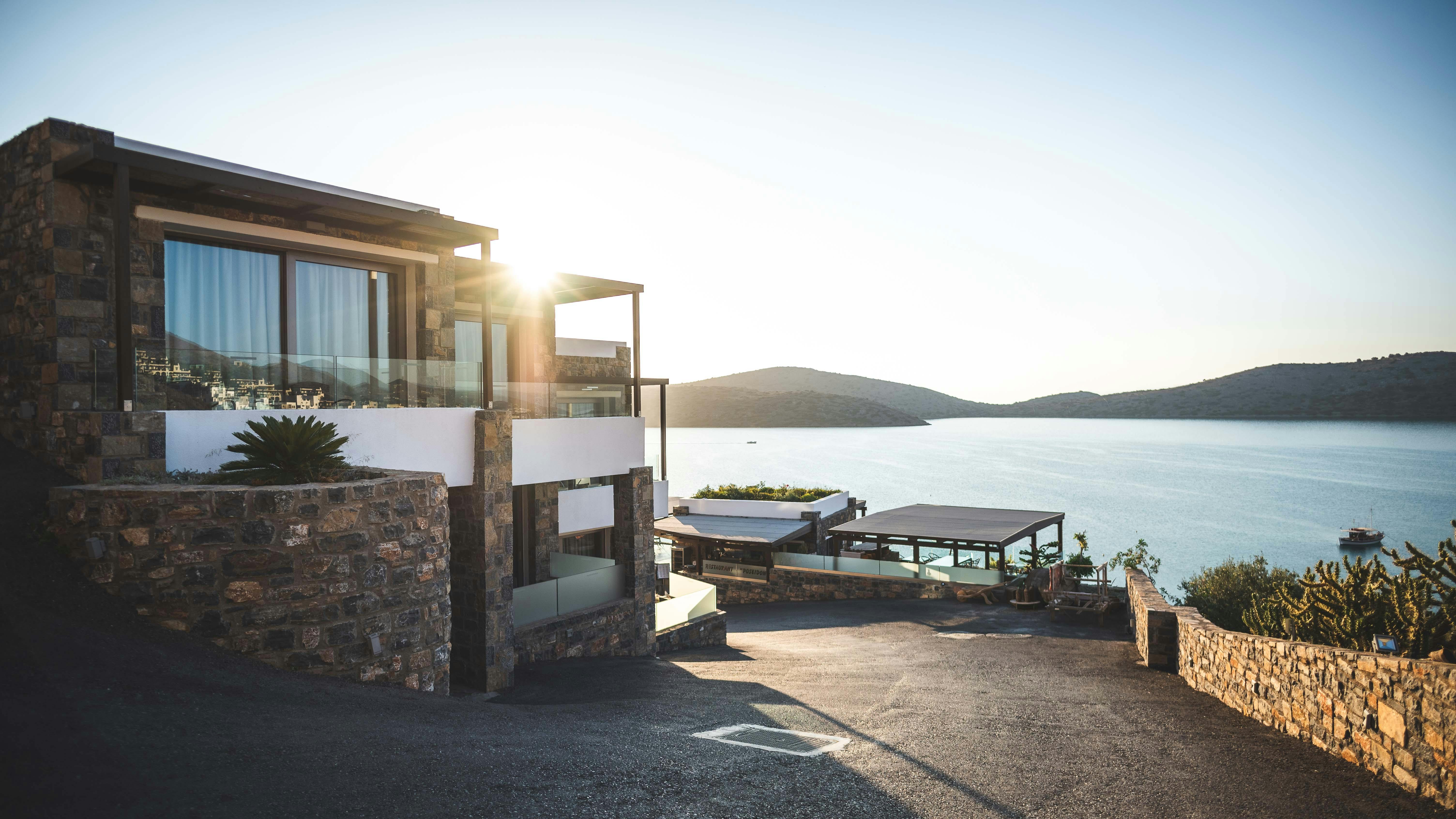 Stone waterfront home overlooking the sea at sunset
